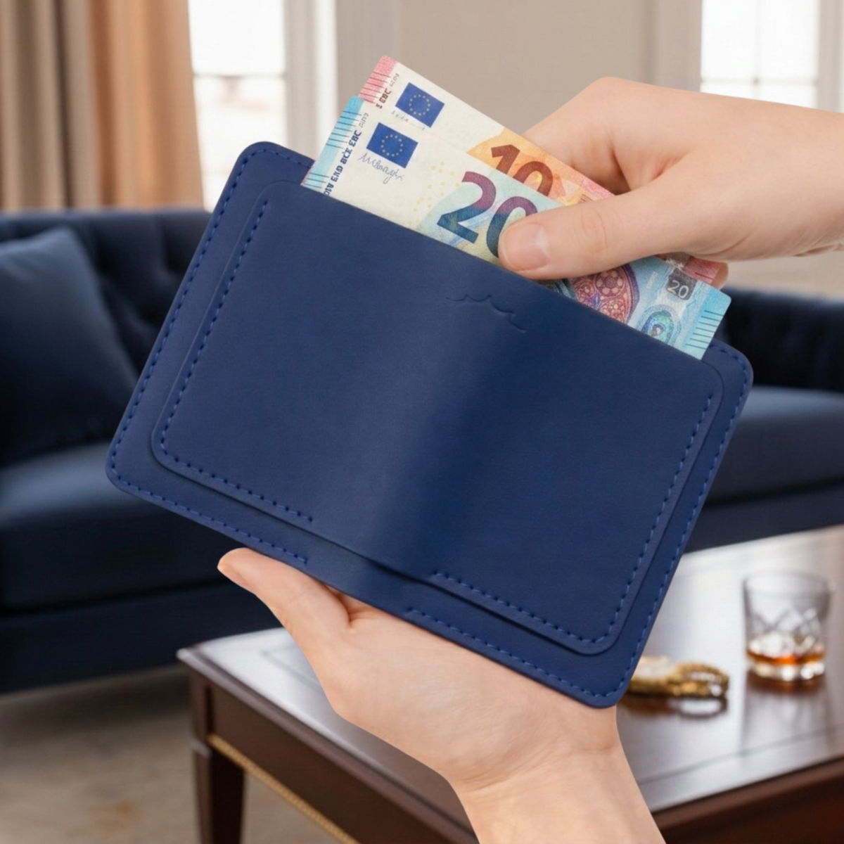 Porte-cartes et billets The Fold Co en cuir pleine fleur bleu océan avec coutures contrastées, tenu en main.