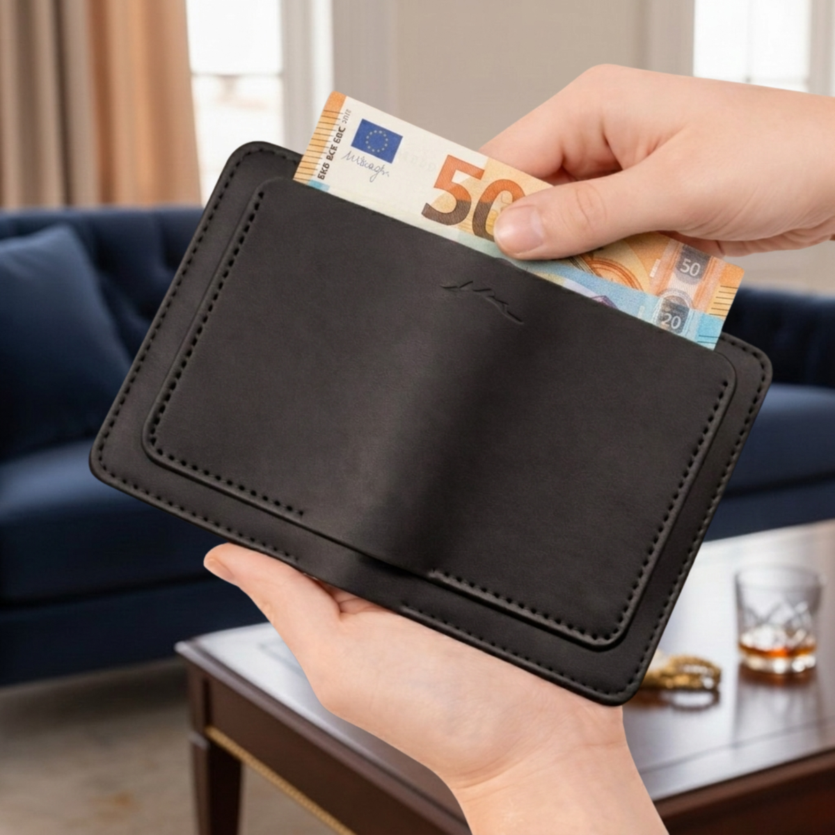 Porte-cartes The Fold Co en cuir pleine fleur noir avec coutures contrastées et billets insérés dans la fente centrale